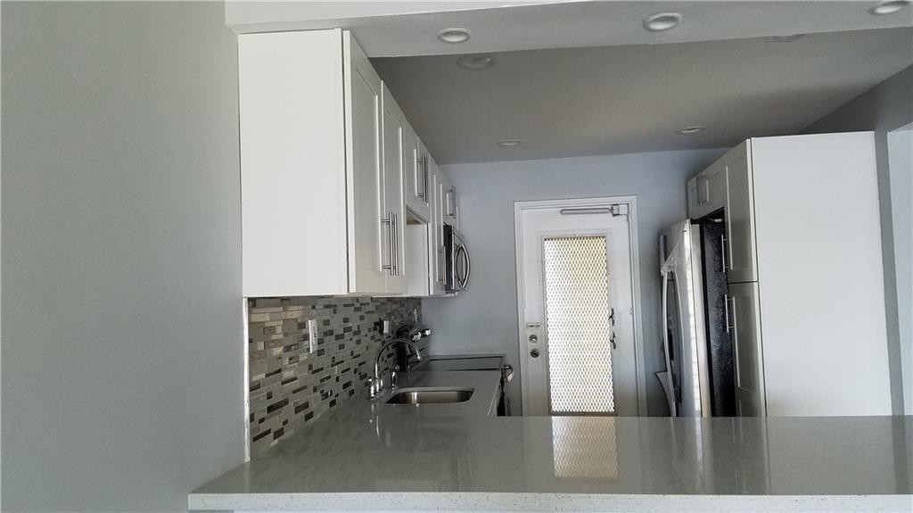 a view of a kitchen with a refrigerator and a window