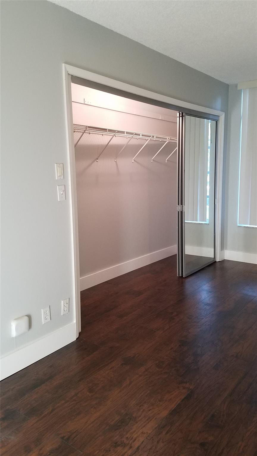 3100 North Course Lane, Unit 210 Pompano Beach, FL 33069 - Photo 13 of 28 an empty room with wooden floor and windows