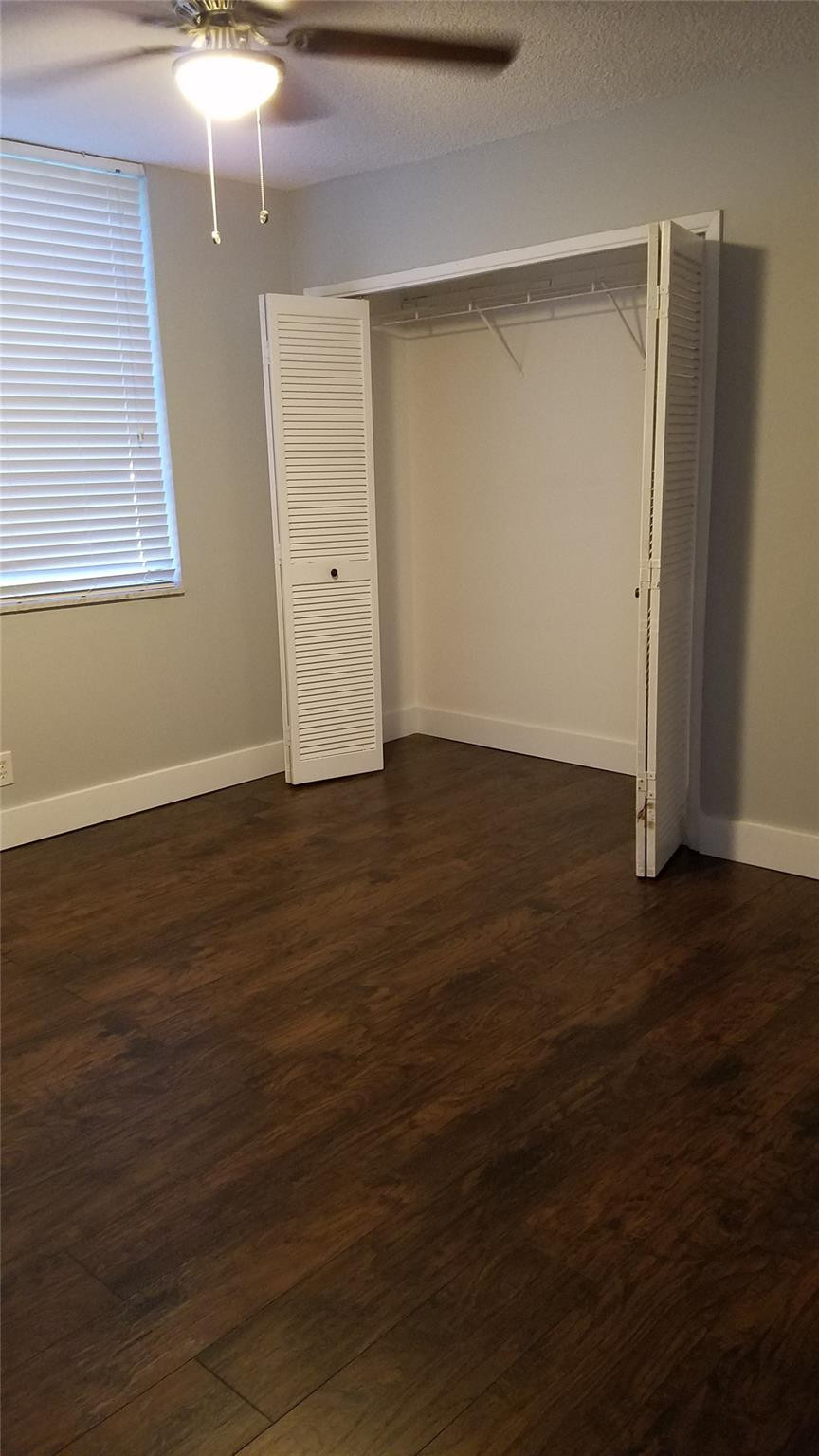 3100 North Course Lane, Unit 210 Pompano Beach, FL 33069 - Photo 15 of 28 an empty room with wooden floor and windows