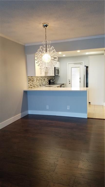 3100 North Course Lane, Unit 210 Pompano Beach, FL 33069 - Photo 5 of 28 a kitchen with kitchen island stainless steel appliances a fireplace and wooden floor