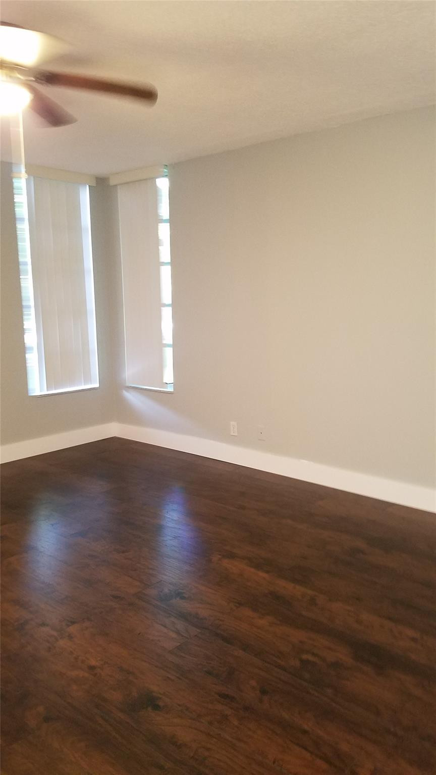 3100 North Course Lane, Unit 210 Pompano Beach, FL 33069 - Photo 9 of 28 a view of an empty room with wooden floor and window