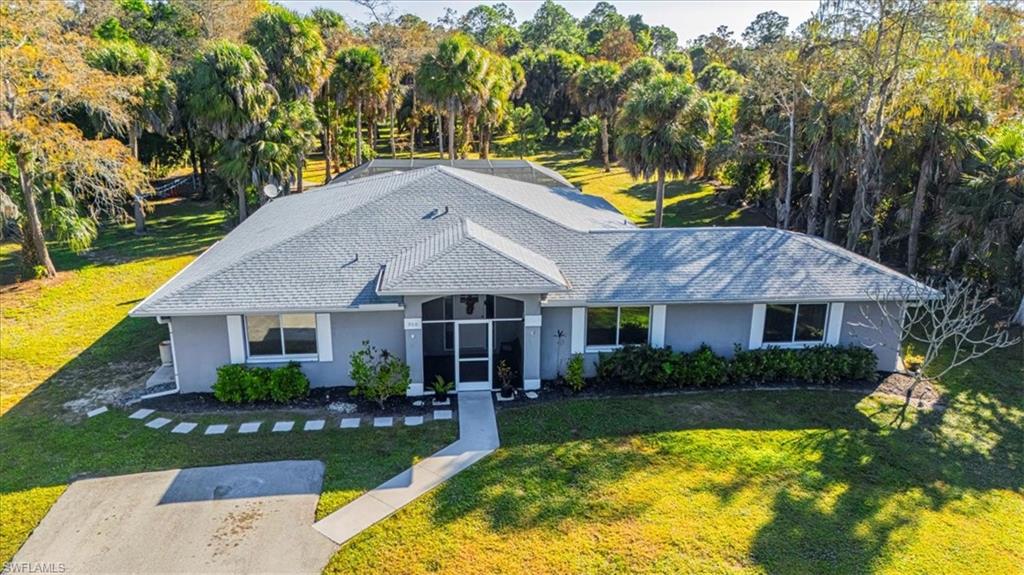 960 21st Street Southwest Naples, FL 34117 - Photo 1 of 33 a house view with a swimming pool and garden
