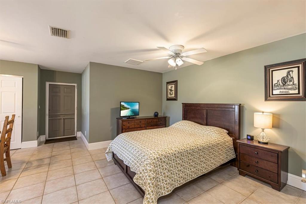 960 21st Street Southwest Naples, FL 34117 - Photo 23 of 33 a bedroom with a bed and a chandelier