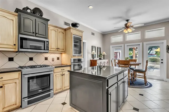 a kitchen with kitchen island a stove a sink and a microwave