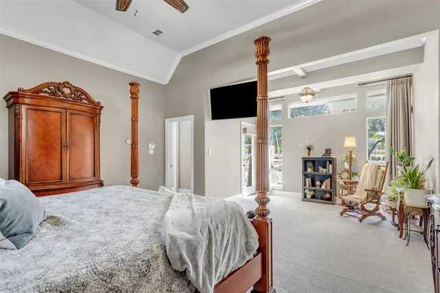 a bedroom with a bed a flat screen tv and dresser