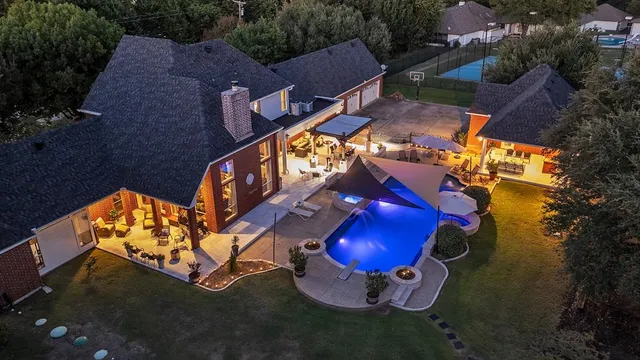 an aerial view of a house with swimming pool outdoor seating and yard
