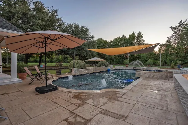 a view of a patio with a table and chairs under an umbrella