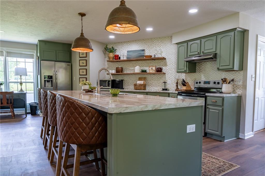 6938 Story Mill Road Hephzibah, GA 30815 - Photo 18 of 36 a kitchen with stainless steel appliances granite countertop a sink a stove and a wooden floors