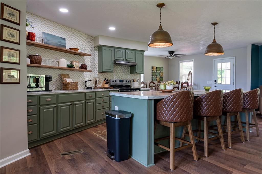 6938 Story Mill Road Hephzibah, GA 30815 - Photo 21 of 36 a kitchen with stainless steel appliances granite countertop a sink a stove and a wooden floors