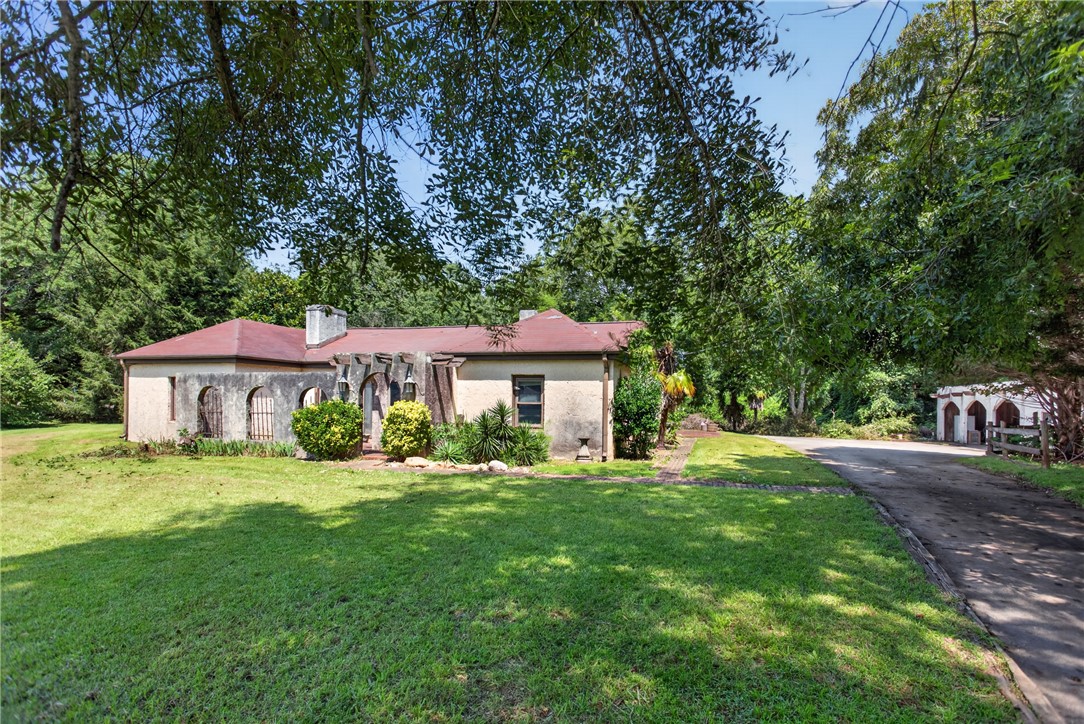 1719 Old Central Road Central, SC 29630 - Photo 2 of 45 Mature trees shade a charming stucco facade set back on a generous grassy lot.