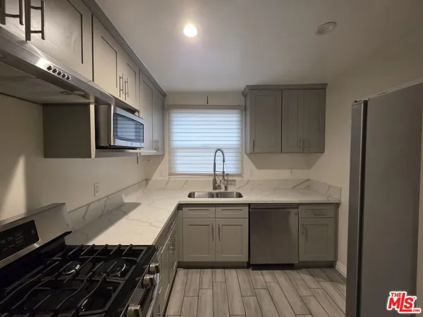 a kitchen with stainless steel appliances a sink stove and cabinets