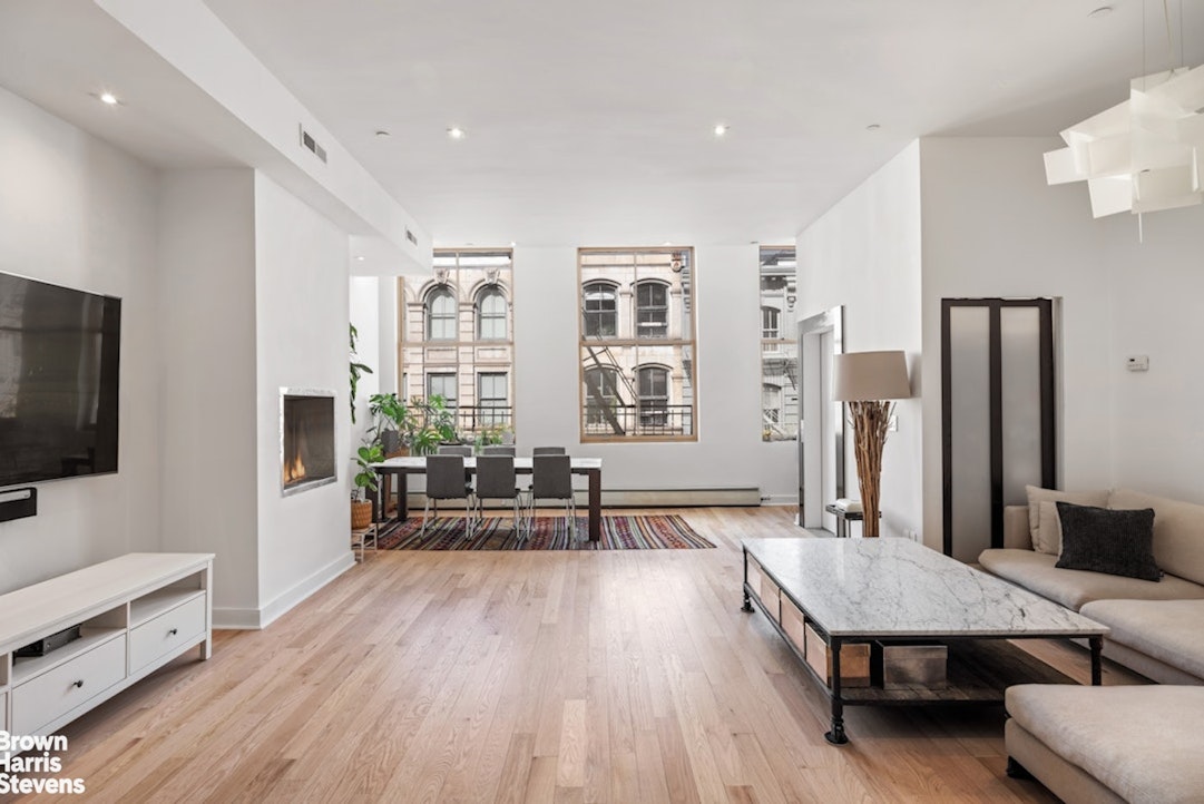 a living room with furniture wooden floor and a flat screen tv