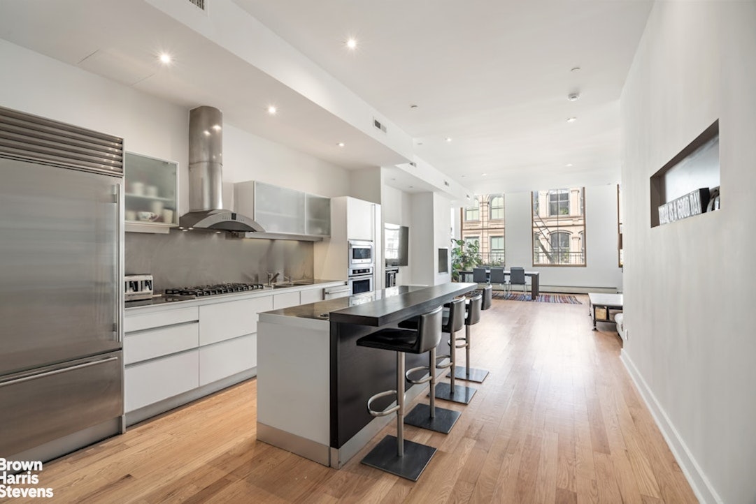 461 Broome Street, Unit 4 Manhattan, NY 10013 - Photo 2 of 14 a kitchen with sink cabinets and wooden floor