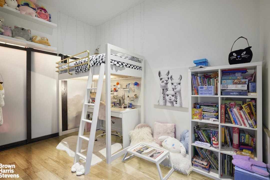 461 Broome Street, Unit 4 Manhattan, NY 10013 - Photo 6 of 14 a living room with lots of furniture and a book shelf