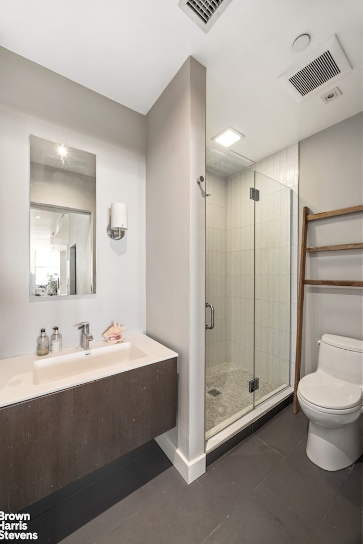 461 Broome Street, Unit 4 Manhattan, NY 10013 - Photo 7 of 14 a bathroom with a double vanity sink toilet and shower