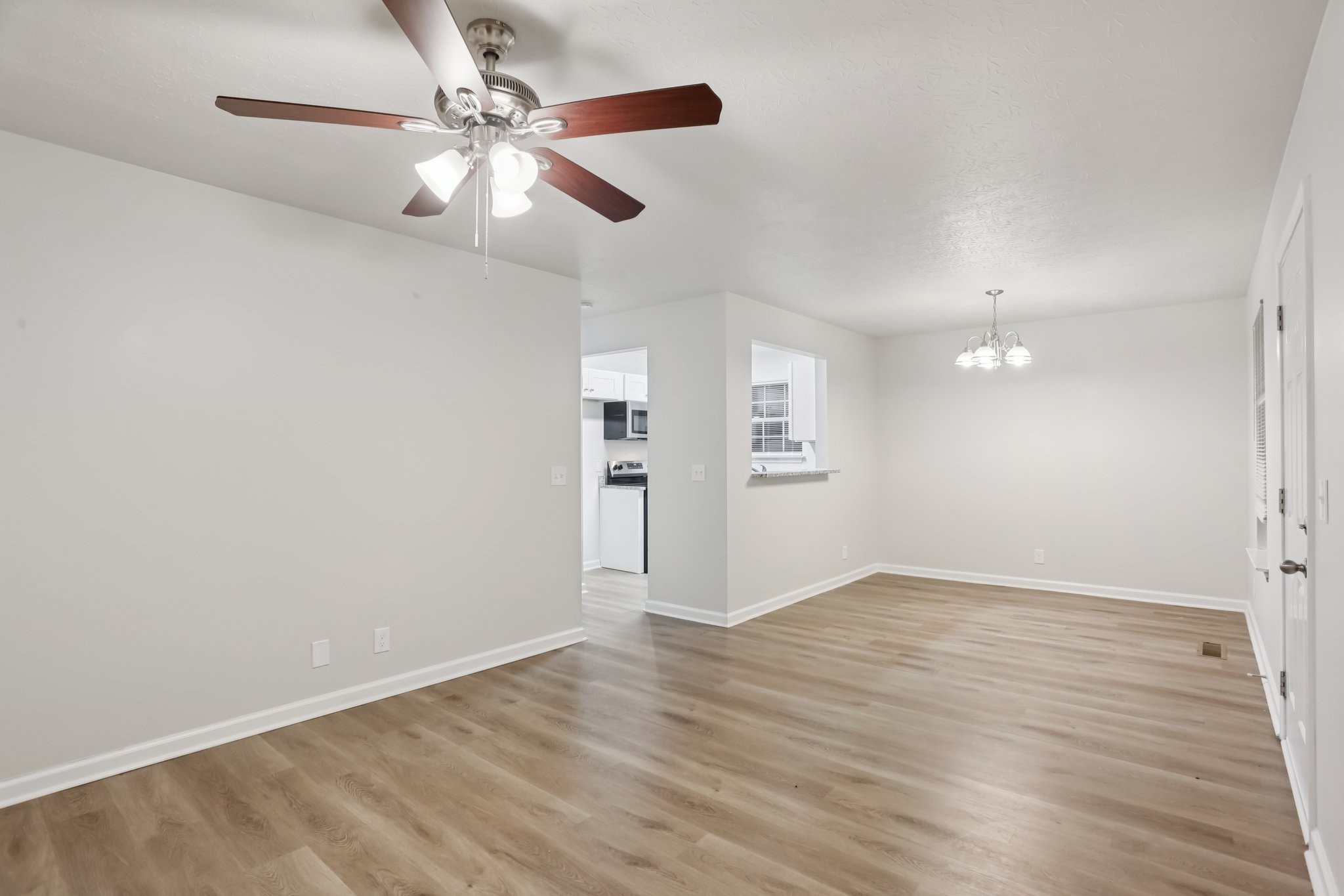 2607 Landrum Court Springfield, TN 37172 - Photo 11 of 37 an empty room with wooden floor chandelier fan and windows
