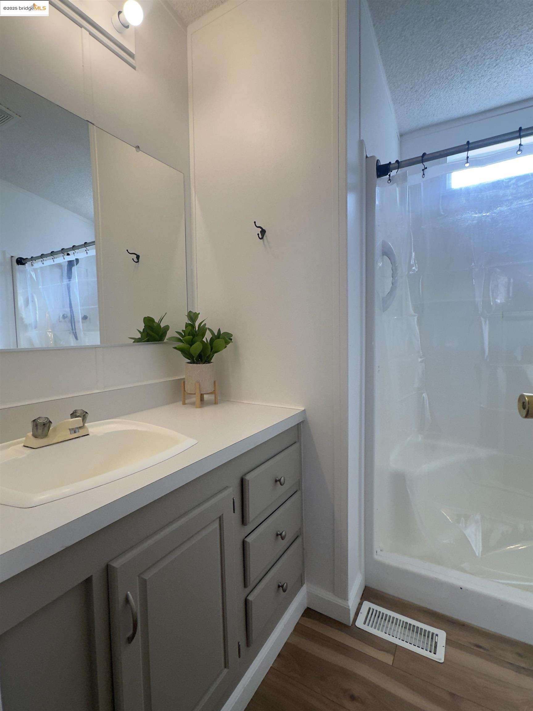 14192 Tuolumne Road, Unit 5 Sonora, CA 95370 - Photo 6 of 10 Bathroom with a textured ceiling, a shower with curtain, vanity, and dark wood-type flooring