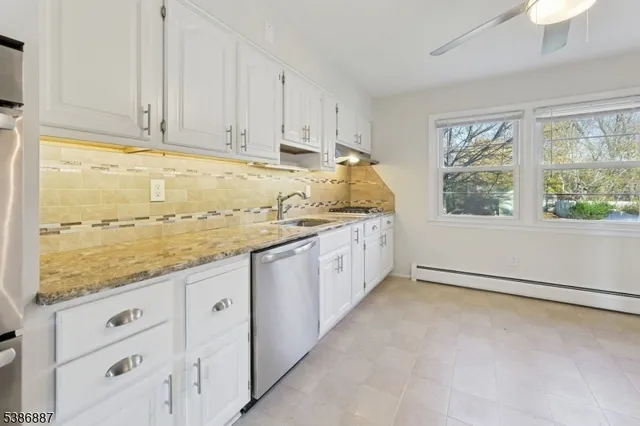 a view of a kitchen with granite countertop cabinets stainless steel appliances and a window