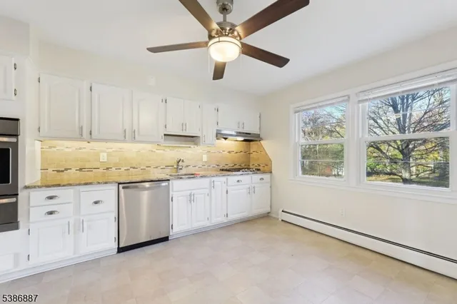 a kitchen with granite countertop stainless steel appliances white cabinets and a granite counter tops