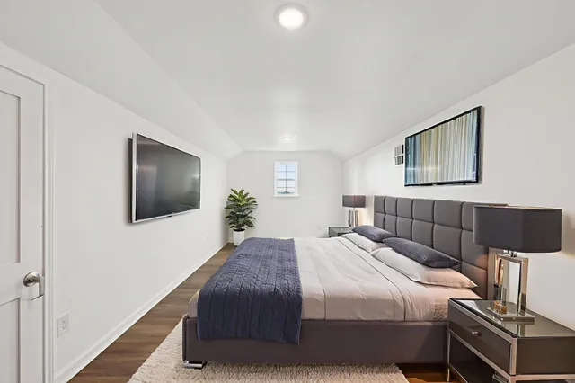 a bedroom with a bed and a flat screen tv