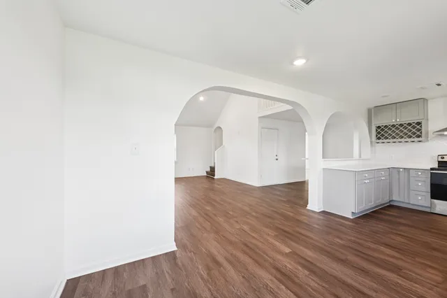 a view of empty room with wooden floor