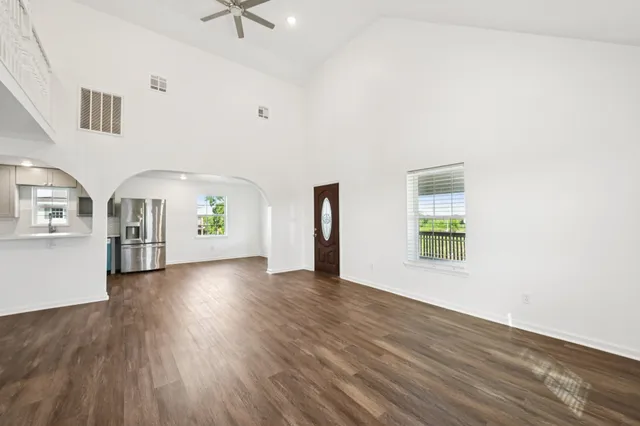 a view of an empty room with a window and wooden floor
