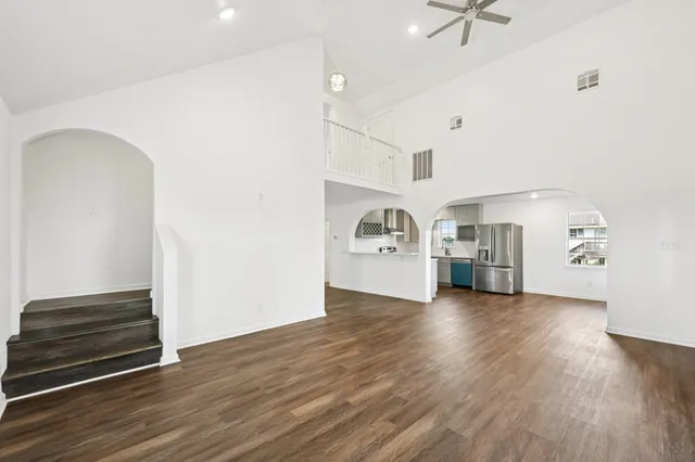 a view of empty room with kitchen and window
