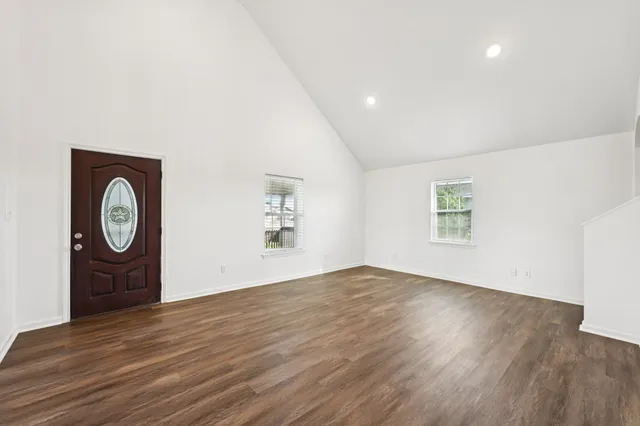 an empty room with wooden floor and a window