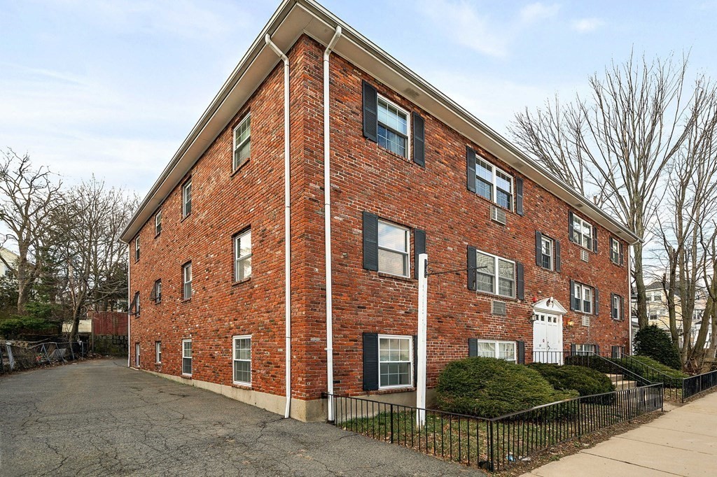 217 Neponset Avenue, Unit 33 Boston, MA 02122 - Photo 2 of 12 a view of a brick building next to a yard