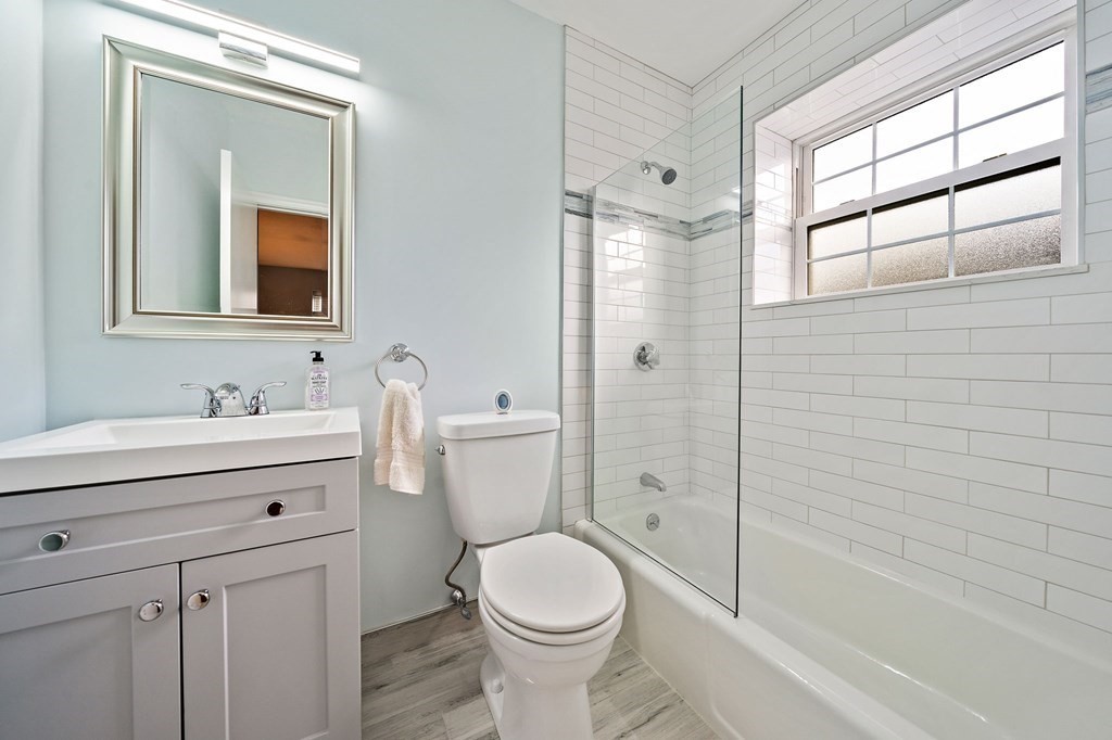 217 Neponset Avenue, Unit 33 Boston, MA 02122 - Photo 8 of 12 a bathroom with a toilet a sink a mirror a bathtub and shower