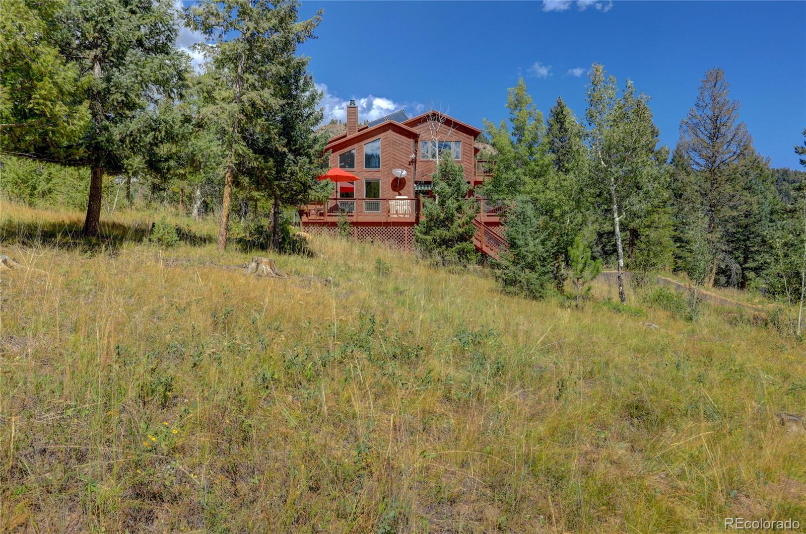 20174 Silver Ranch Road Conifer, CO 80433 - Photo 36 of 40 a view of house with tall trees in the background