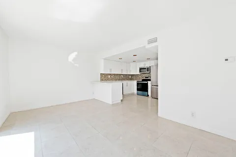 a view of kitchen with refrigerator stove and cabinets