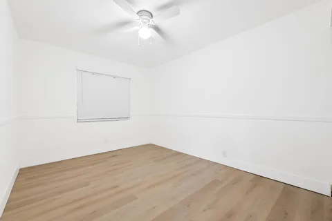an empty room with a empty space and a ceiling fan