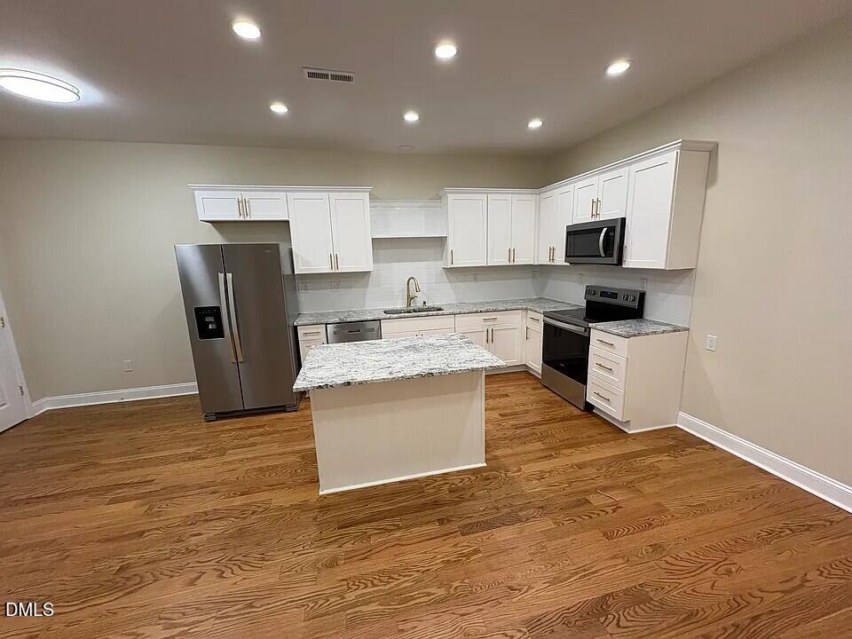 a large kitchen with stainless steel appliances granite countertop a stove a sink and a refrigerator