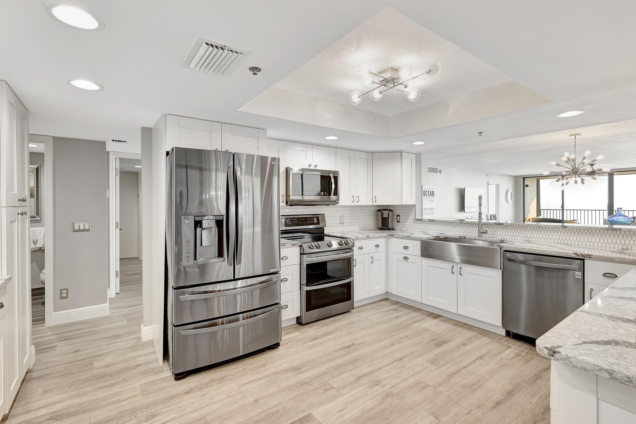 4000 North Hwy A1A, Unit 402 Hutchinson Island, FL 34949 - Photo 15 of 60 a large kitchen with cabinets wooden floor and stainless steel appliances