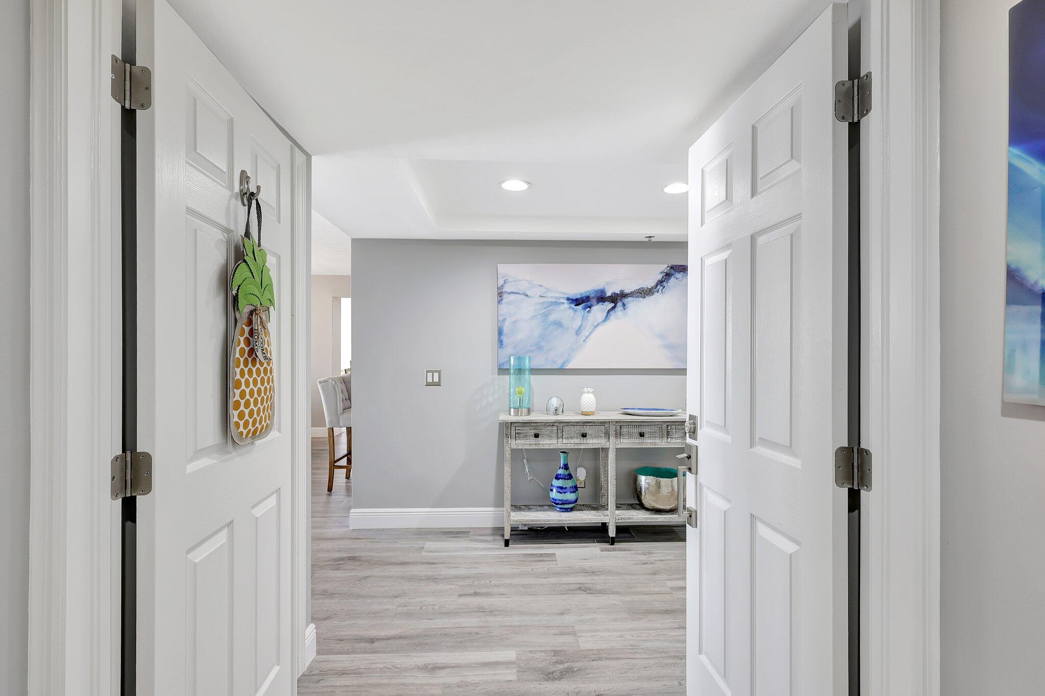 4000 North Hwy A1A, Unit 402 Hutchinson Island, FL 34949 - Photo 3 of 60 a view of a hallway with wooden floor and furniture