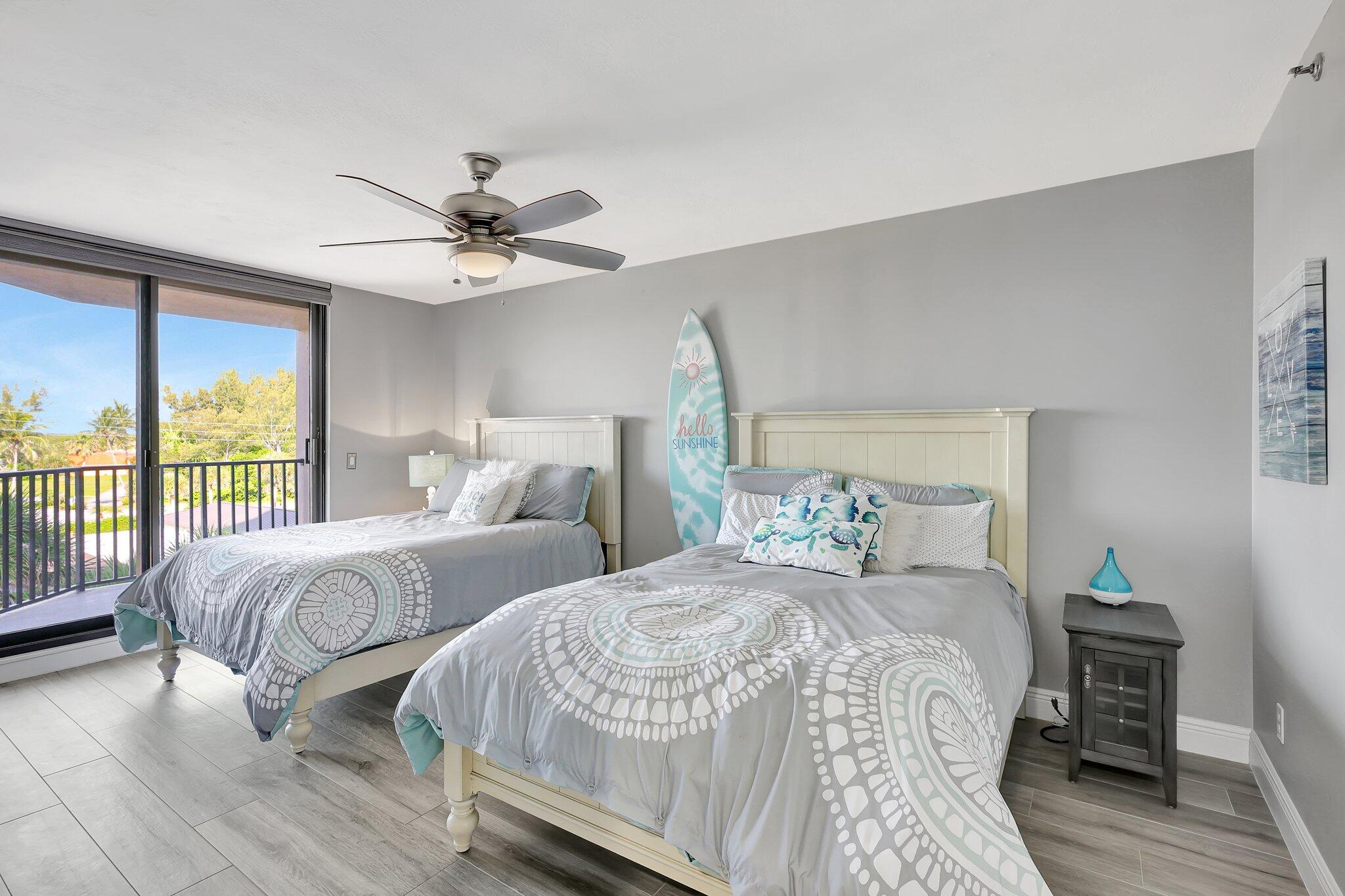 4000 North Hwy A1A, Unit 402 Hutchinson Island, FL 34949 - Photo 38 of 60 a bedroom with two beds and a large window with balcony view