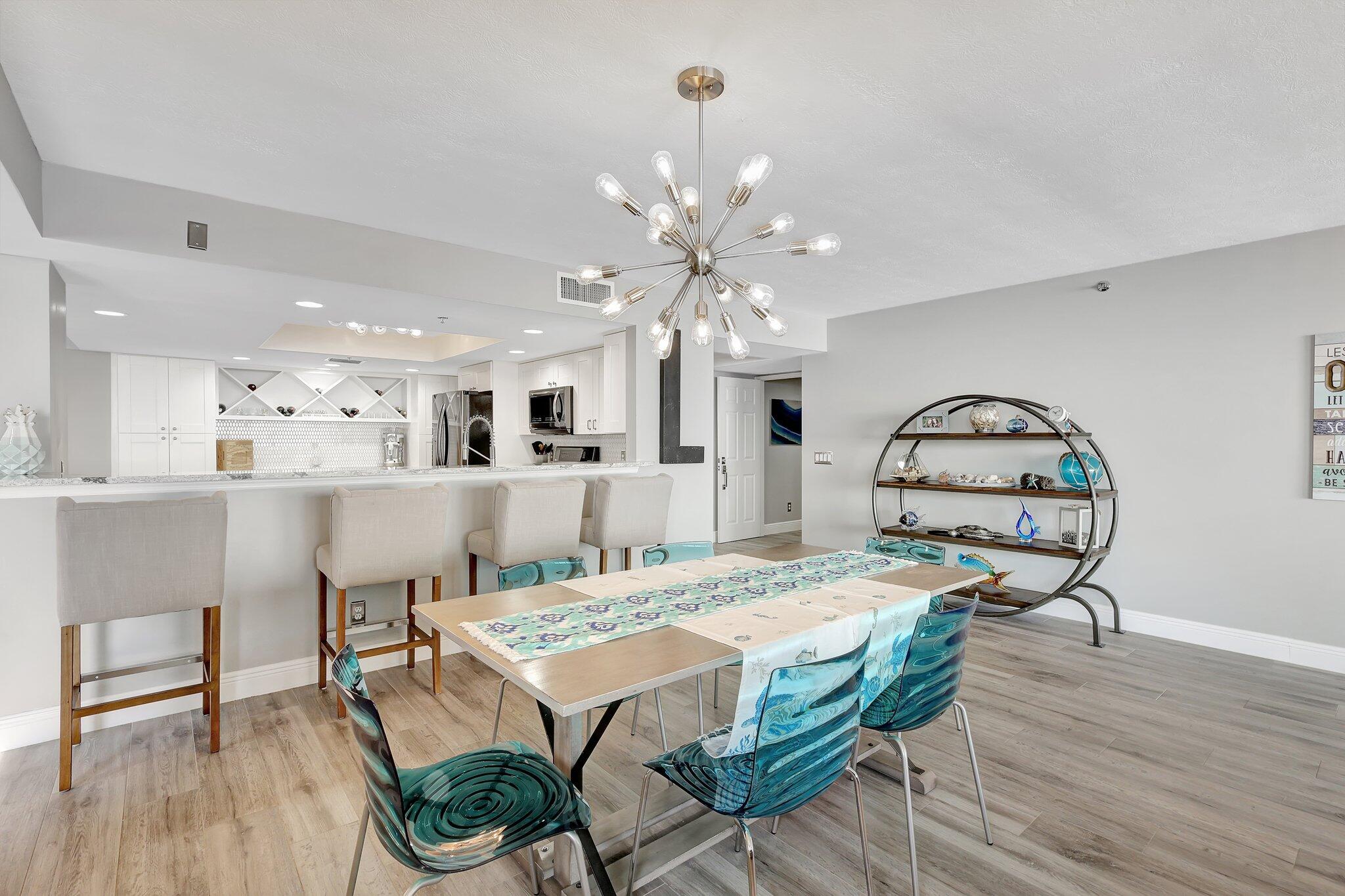 4000 North Hwy A1A, Unit 402 Hutchinson Island, FL 34949 - Photo 6 of 60 a dining room with furniture a chandelier and wooden floor