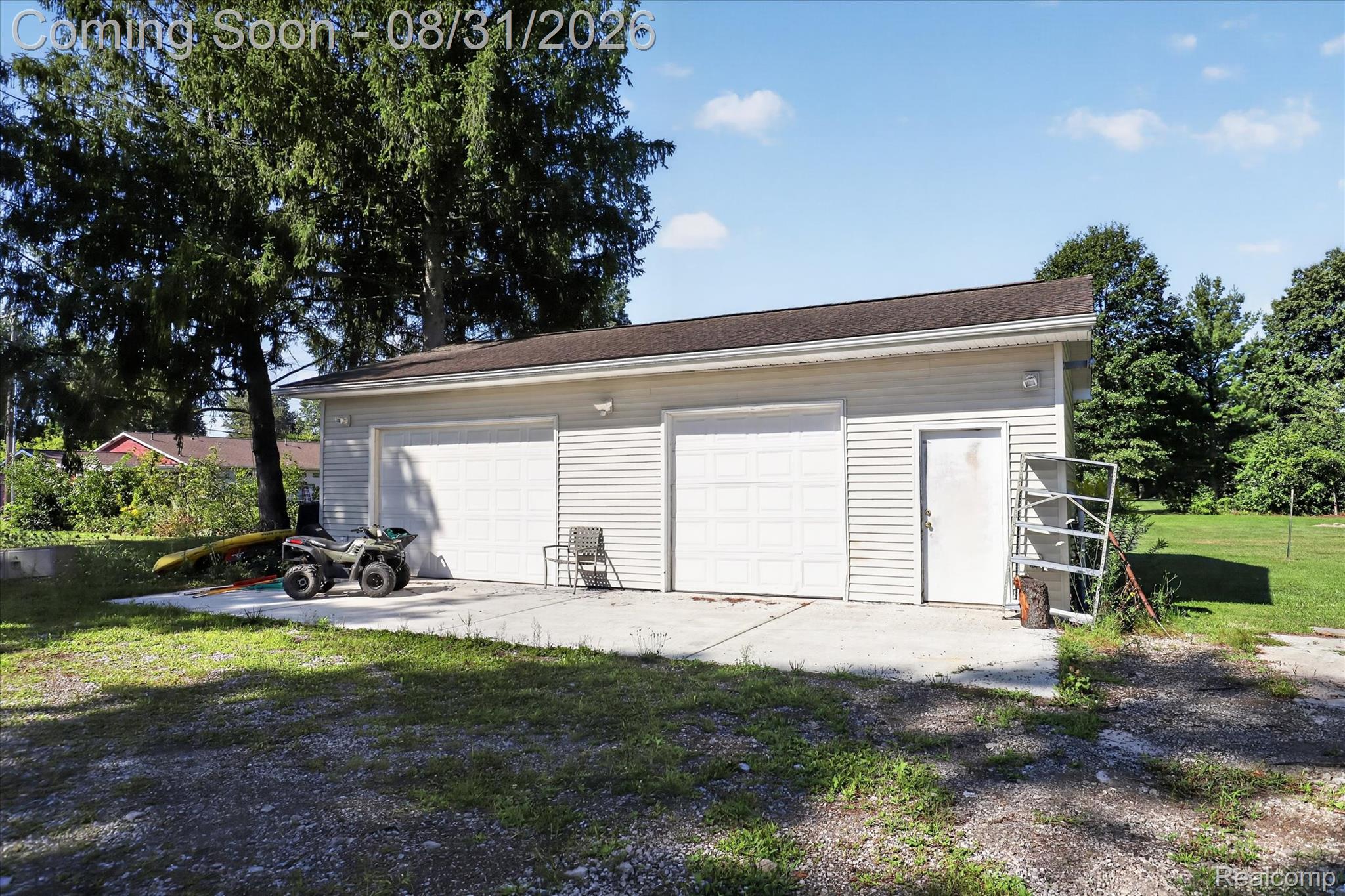 10165 Talladay Road Willis, MI 48191 - Photo 46 of 56 Detached garage with two roll-up doors, a side entry door, and vinyl siding