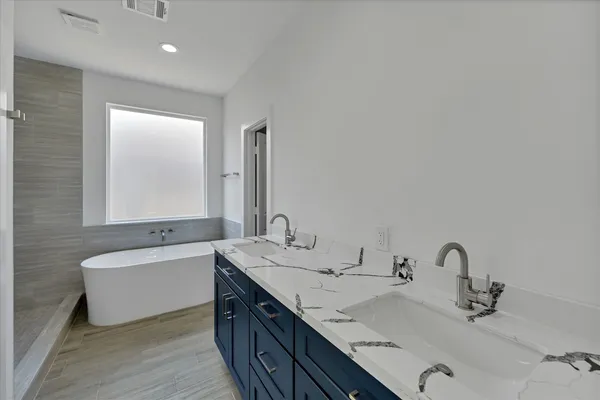 a bathroom with a double vanity sink and a bathtub