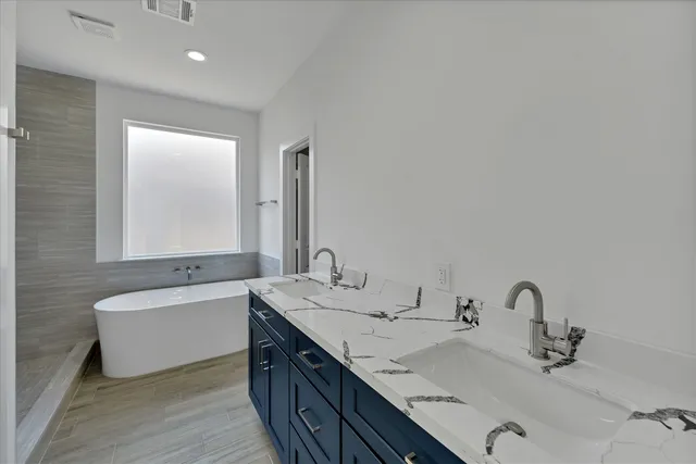 a bathroom with a double vanity sink and a bathtub