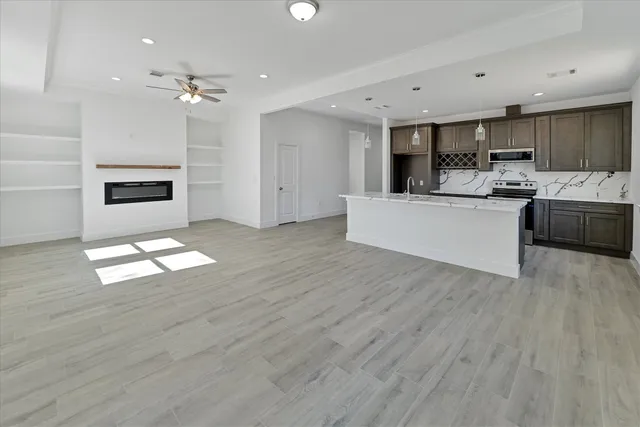 a living room with stainless steel appliances kitchen island hardwood floor and living room view