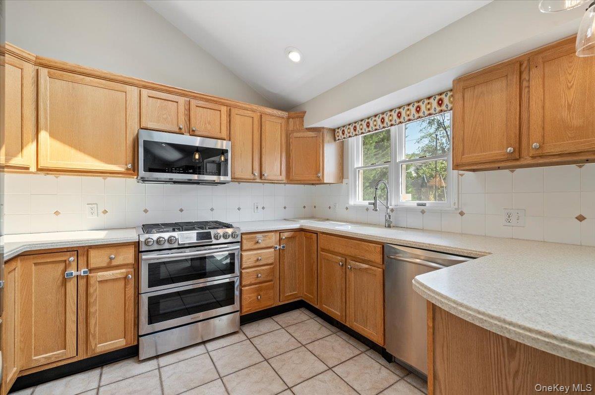 214 Haypath Road Old Bethpage, NY 11804 - Photo 11 of 27 a kitchen with stainless steel appliances a stove sink microwave and cabinets