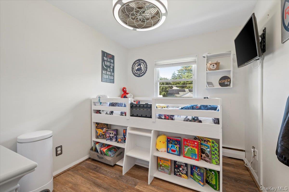 214 Haypath Road Old Bethpage, NY 11804 - Photo 18 of 27 a room with furniture a flat screen tv and a window