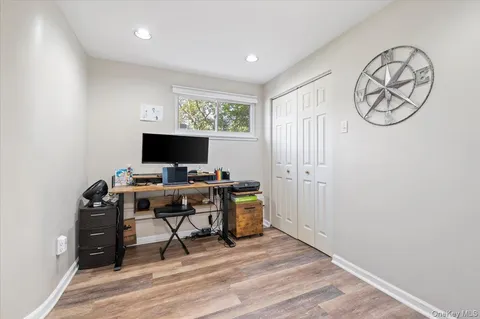 a view of a workspace with furniture and a window