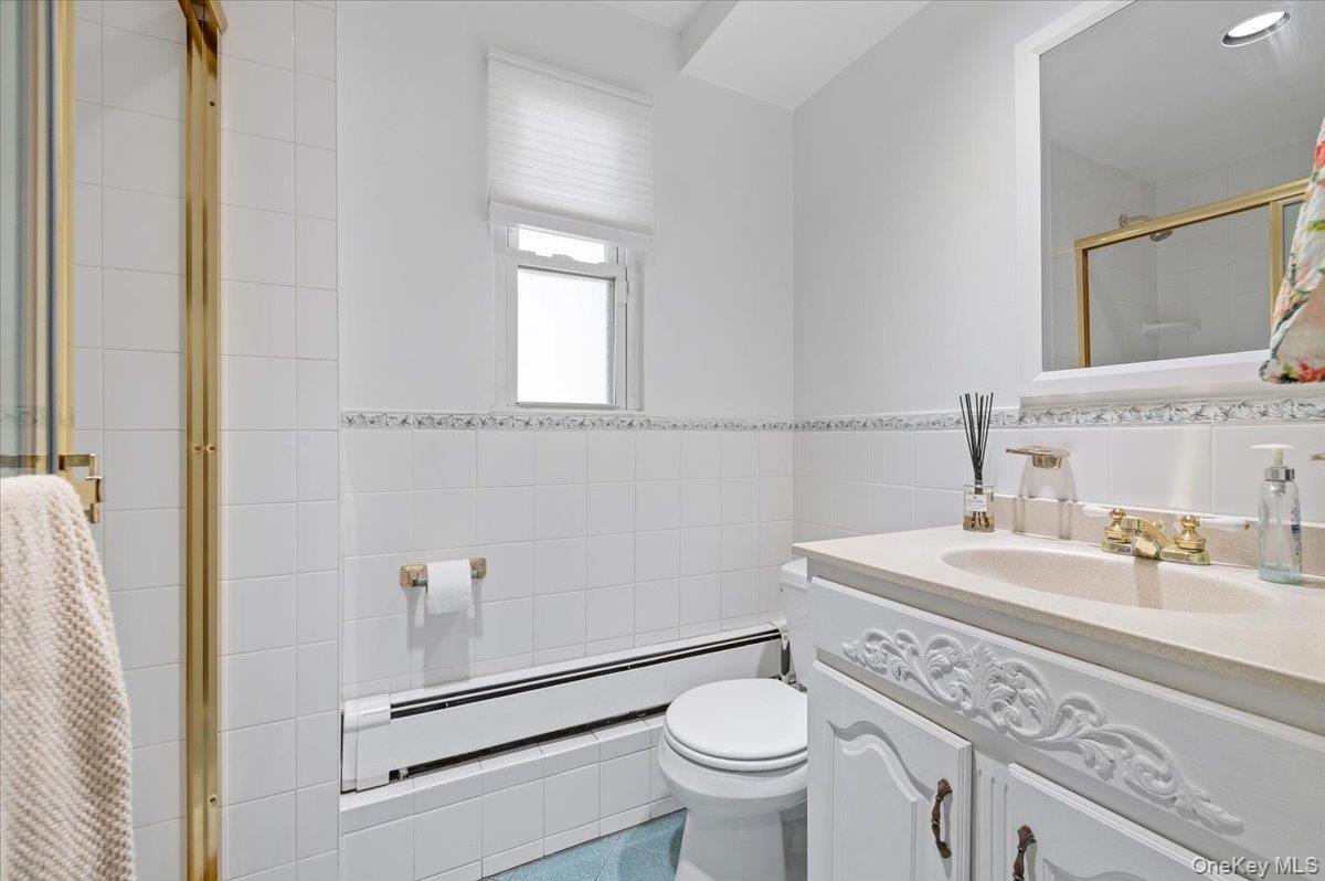 214 Haypath Road Old Bethpage, NY 11804 - Photo 7 of 27 a bathroom with a sink toilet vanity and mirror