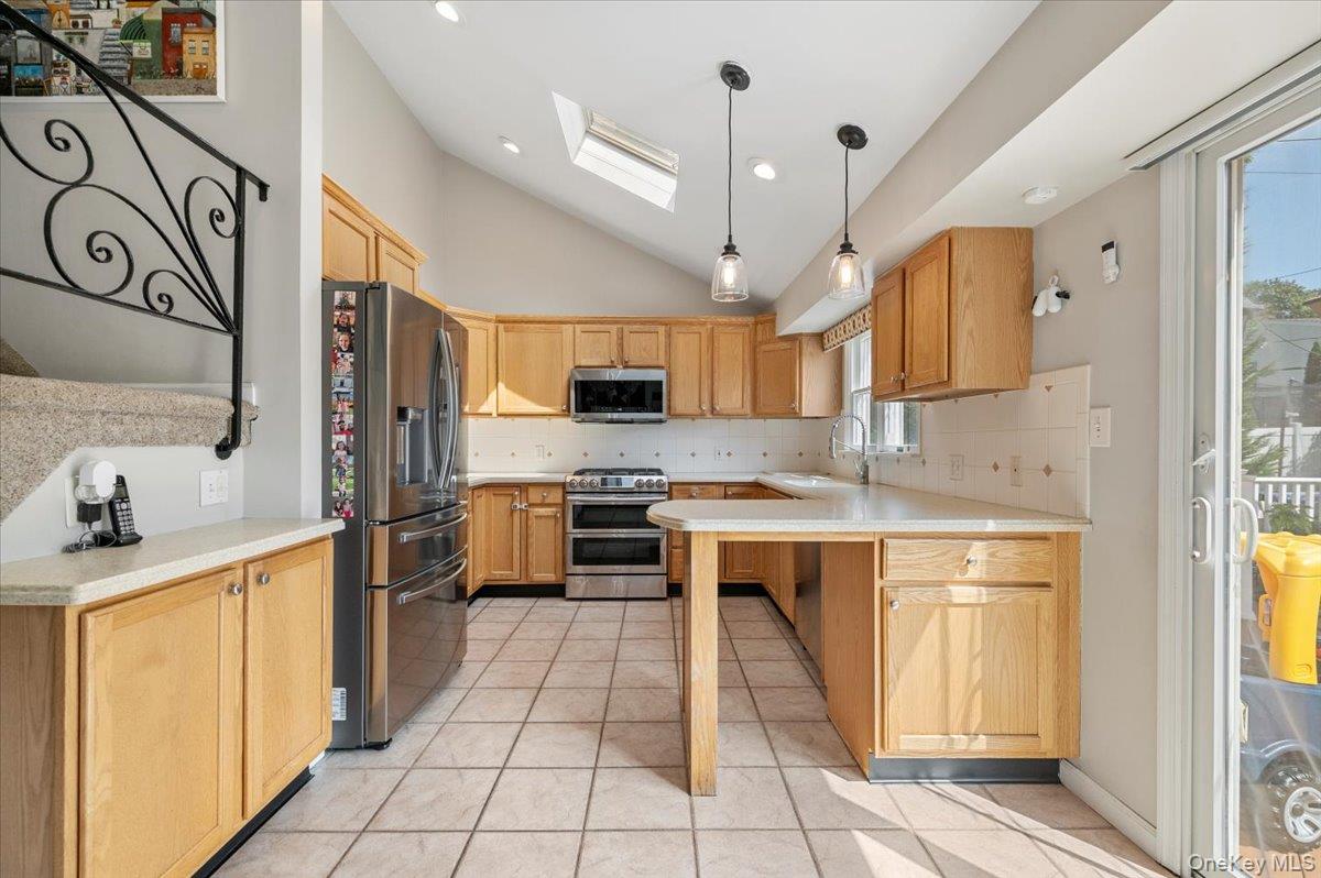 214 Haypath Road Old Bethpage, NY 11804 - Photo 9 of 27 a kitchen with stainless steel appliances a sink a stove a refrigerator cabinets and a window