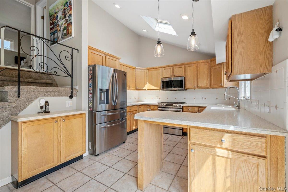 214 Haypath Road Old Bethpage, NY 11804 - Photo 10 of 27 a kitchen with stainless steel appliances granite countertop a sink a stove a refrigerator a microwave oven with white cabinets