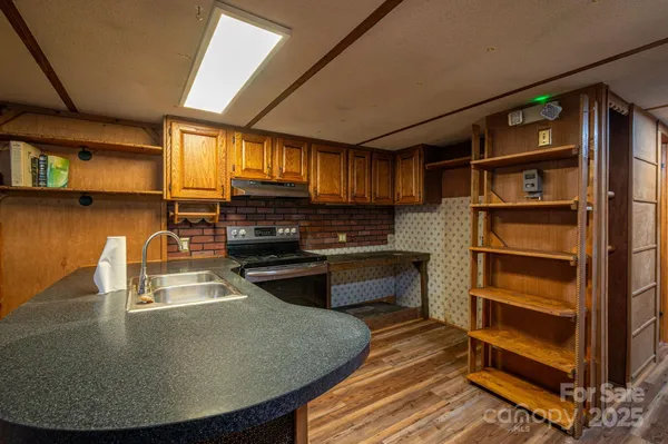 a kitchen with kitchen island a stove and a sink