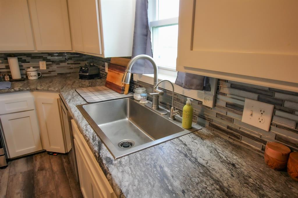 3061 Turkey Creek Road Sunset, TX 76270 - Photo 25 of 38 a kitchen with a sink stove and cabinets
